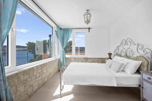 una camera da letto con un letto e una grande finestra di Boutique Guesthouse Sveti Petar, on the beach, heated pool & boat berth - ADULT ONLY a Nečujam