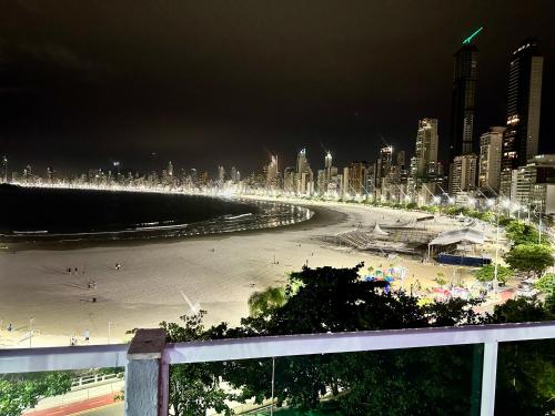 vista para uma praia à noite com uma cidade em Studio Pé na Areia II em Balneário Camboriú