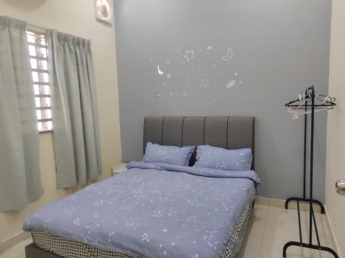 Schlafzimmer mit einem Bett mit blauer Decke in der Unterkunft My Homestay Sitiawan - Astronaut Space House 8 Pax in Sitiawan