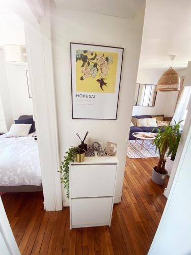 - une chambre avec un lit blanc et une table blanche dans l'établissement Charmant appartement à 10 mn de Paris, à Maisons-Alfort