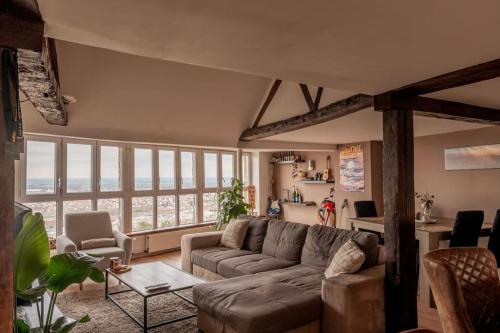 a living room with a couch and a table at Duplex atypique dans la cité médiévale in Laon