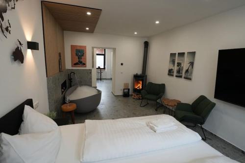 a bedroom with a bed and a tub and a fireplace at Suite mit Badewanne, Kamin und Parkplatz in Graz