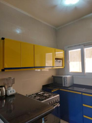 a kitchen with yellow cabinets and a stove at Mousa Coast aquapark view chalet with garden in Ras Sedr