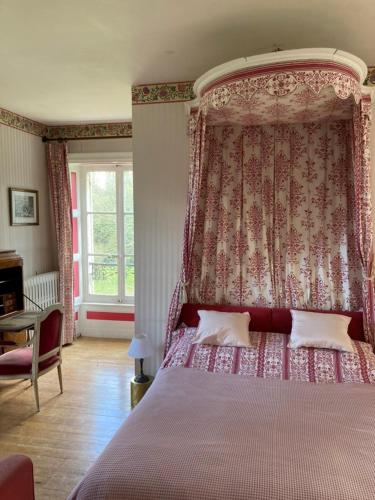 une chambre avec un grand lit à baldaquin dans l'établissement Château de Goville, à Le Breuil-en-Bessin