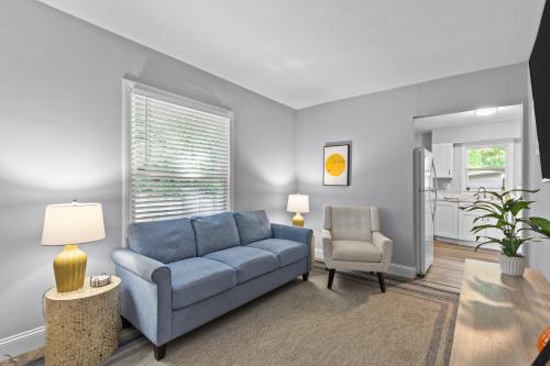 a living room with a blue couch and a chair at Duplex Hideaway in Saint Charles MO in St. Charles