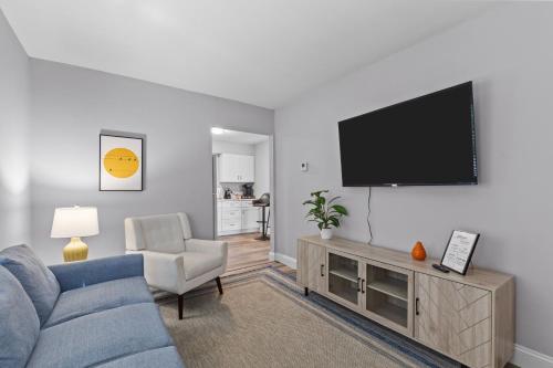 a living room with a blue couch and a flat screen tv at Duplex Hideaway in Saint Charles MO in St. Charles