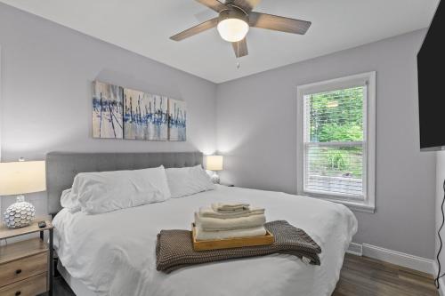 a bedroom with a white bed with a ceiling fan at Duplex Hideaway in Saint Charles MO in St. Charles