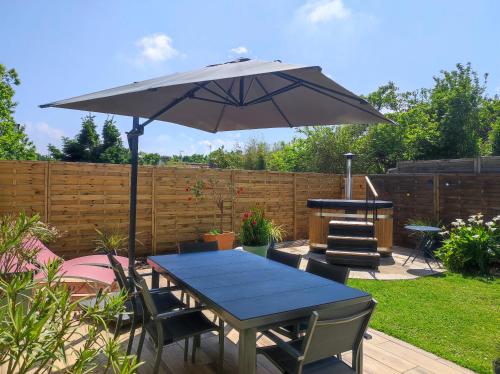 a patio with a table and an umbrella at La Sapinière in Perros-Guirec