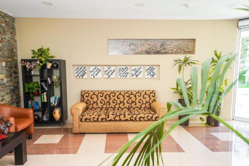 a living room with a couch and a plant at Hotel Pradillo Conil in Conil de la Frontera