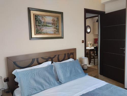 a bedroom with a bed with blue pillows and a picture on the wall at Christina's House - Neochori / Pelion in Neochori