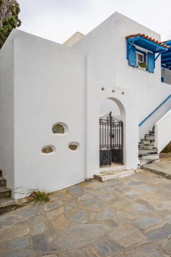 a white building with a black gate and stairs at FEEL THE SERENITY in Galini
