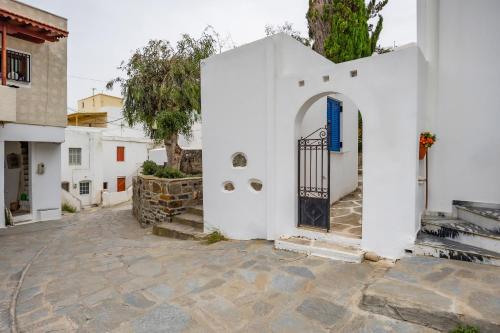 a white building with a blue door on a street at FEEL THE SERENITY in Galini