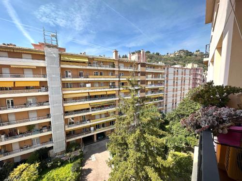 un grand immeuble avec des arbres devant lui dans l'établissement Cosy 2 pièces au calme avec balcon dans le centre ville, à Menton