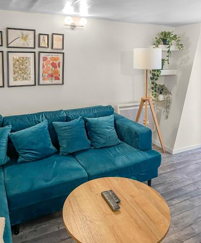 un salon avec un canapé bleu et une table dans l'établissement Appartement Trendy et Cosy à St Ouen, à Saint-Ouen