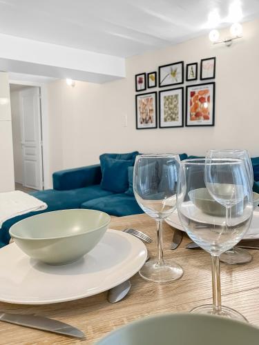 - une table avec 2 verres à vin et un bol dans l'établissement Appartement Trendy et Cosy à St Ouen, à Saint-Ouen