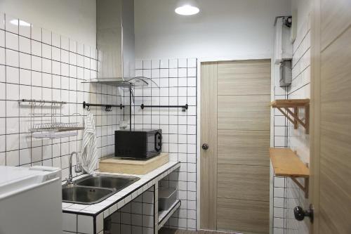 a small kitchen with a sink and a microwave at FineUpHome บ้านพักเหมาหลัง 3 ห้องนอน 2 ห้องน้ำ ห้องครัว ห้องรับแขก ห้องรับประทานอาหาร พร้อมสระว่ายน้ำส่วนตัว in Chiang Khan