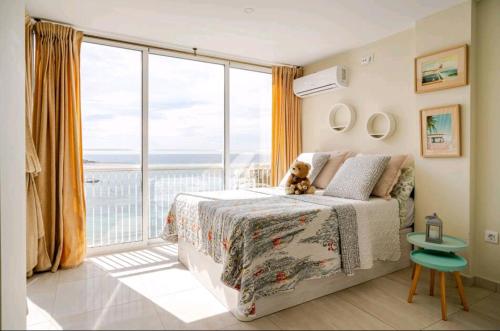 a bedroom with a bed and a large window at bellavista 4 frente a la playa Alicante in Alicante