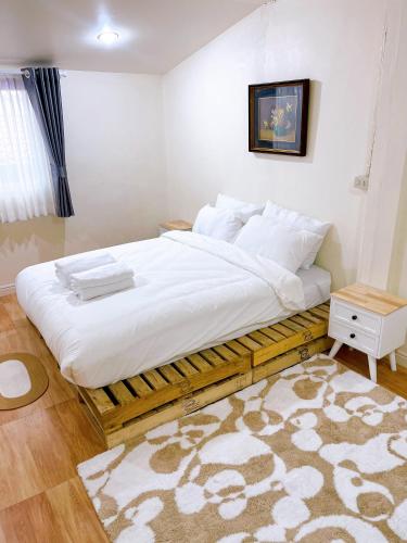 a bed with white sheets and pillows in a bedroom at เซฟเฮาส์ นครสวรรค์ in Nakhon Sawan