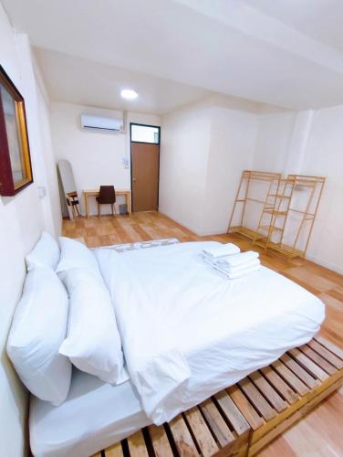 a large bed with white sheets in a room at เซฟเฮาส์ นครสวรรค์ in Nakhon Sawan