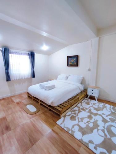 a bedroom with a large white bed and a rug at เซฟเฮาส์ นครสวรรค์ in Nakhon Sawan
