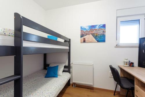 a bedroom with a bunk bed with a desk and a desk at Villa Velum in Mravince