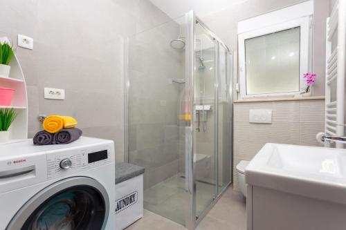 a washing machine in a bathroom with a sink at Villa Velum in Mravince