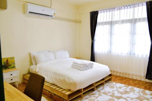 a bedroom with a bed with white sheets and a window at เซฟเฮาส์ นครสวรรค์ in Nakhon Sawan