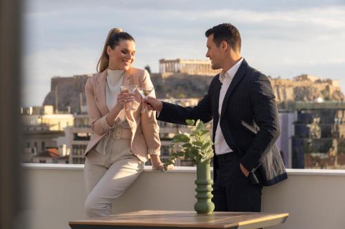 a man and a woman standing on a balcony at Hestia - Asklipiou 9 in Athens