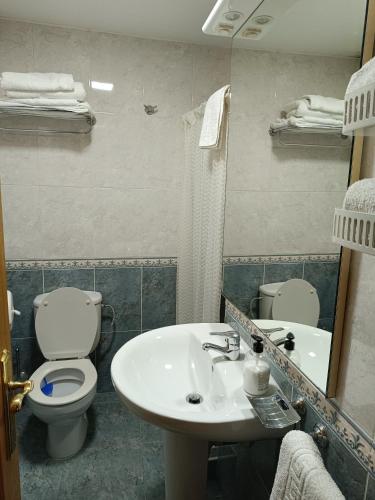 a bathroom with a sink and a toilet and a mirror at APARTAMENTO EDITA in Lugo