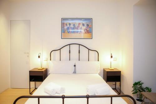 a bedroom with a white bed with two night stands at Magikrooms Kandy in Rome