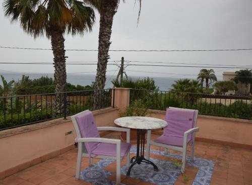 two purple chairs and a table on a balcony at Villa Marinella in Marinella di Selinunte