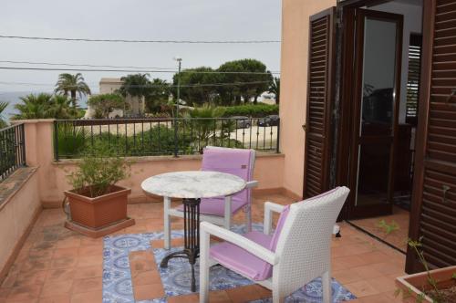 a patio with two chairs and a table on a balcony at Villa Marinella in Marinella di Selinunte
