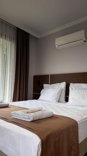 a hotel room with two beds and a window at Gulluk Life Hotel in Gulluk
