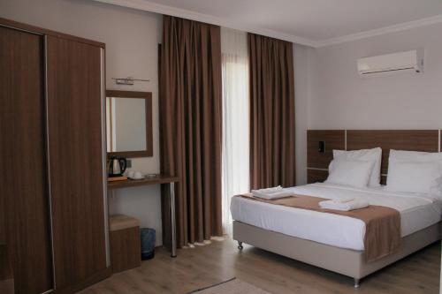 een hotelkamer met een bed en een spiegel bij Gulluk Life Hotel in Gulluk