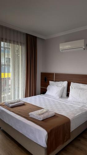 a large bed in a bedroom with a window at Gulluk Life Hotel in Gulluk