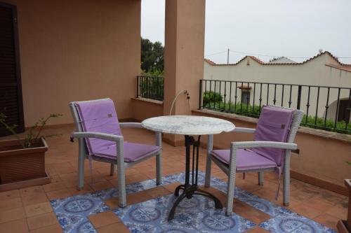 two purple chairs and a table on a balcony at Villa Marinella in Marinella di Selinunte