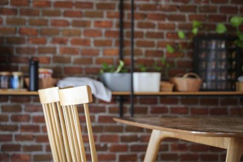 a table and chairs in front of a brick wall at FineUpHome บ้านพักเหมาหลัง 3 ห้องนอน 2 ห้องน้ำ ห้องครัว ห้องรับแขก ห้องรับประทานอาหาร พร้อมสระว่ายน้ำส่วนตัว in Chiang Khan