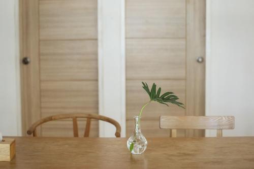 a glass vase with a plant in it on a table at FineUpHome บ้านพักเหมาหลัง 3 ห้องนอน 2 ห้องน้ำ ห้องครัว ห้องรับแขก ห้องรับประทานอาหาร พร้อมสระว่ายน้ำส่วนตัว in Chiang Khan