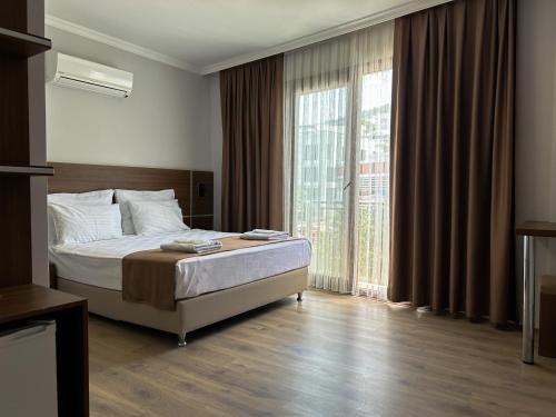 een slaapkamer met een bed en een groot raam bij Gulluk Life Hotel in Gulluk