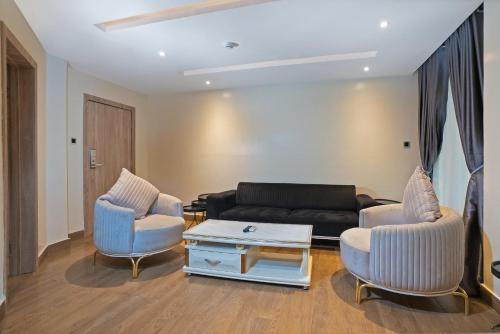 a living room with a couch and two chairs at Watercress Hotels and Event in Ikeja