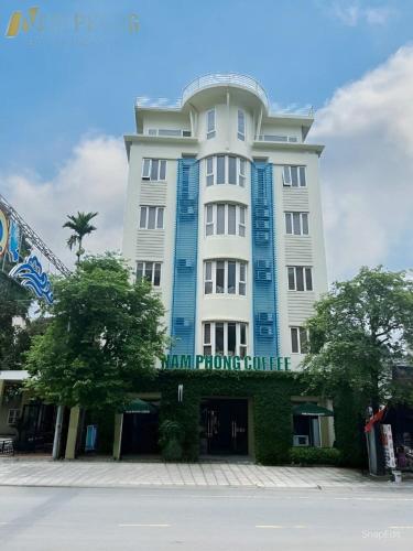 - un grand bâtiment blanc avec un panneau dans l'établissement Nam Phong Hotel & Coffee, à Cái Rồng