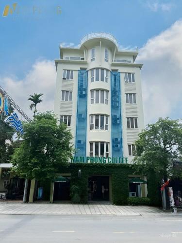 a large white building with a sign on it at Nam Phong Hotel & Coffee in Cái Rồng