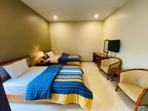 Cette chambre comprend 2 lits et une télévision. dans l'établissement Nam Phong Hotel & Coffee, à Cái Rồng