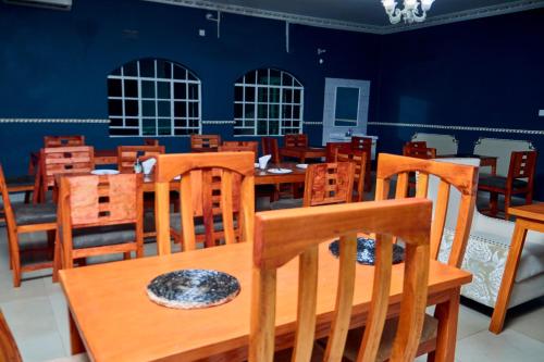 a dining room with wooden tables and chairs at Mpatsa Quest Hotels in Lilongwe
