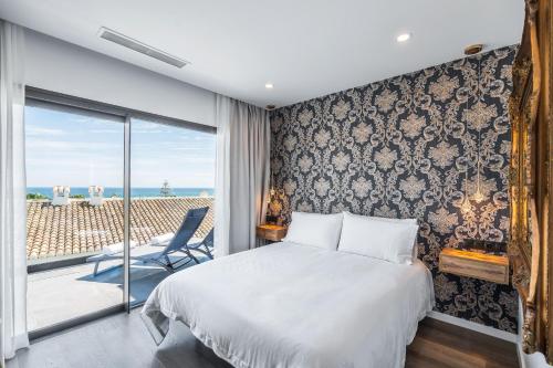 a bedroom with a bed and a view of the ocean at The Orange House Boutique Hotel and Upstairs Rooftop Bar Center of La Cala de Mijas 100m from the Beach in La Cala de Mijas
