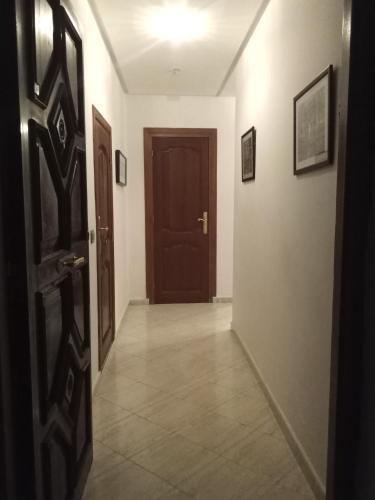 an empty hallway with a door and a tile floor at Miramar Martil à 2 min de la plage in Martil
