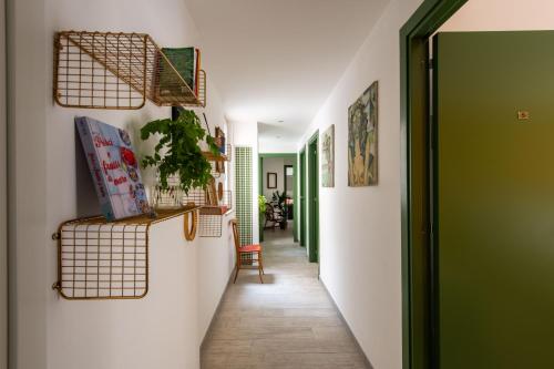 a hallway with green and white walls and a green door at Pretoria Rooms in Palermo