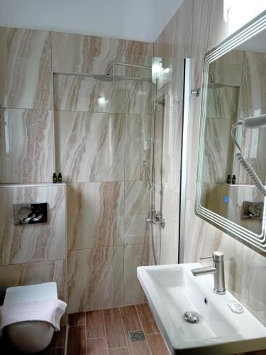 a bathroom with a sink and a shower at Studios Spiros Parga in Parga