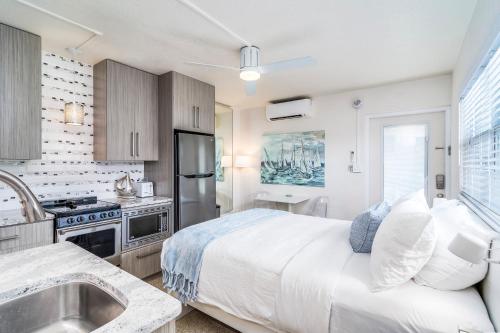 a bedroom with a bed and a kitchen with a sink at Boutique Vacation Rental Complex At Beach in Cocoa Beach