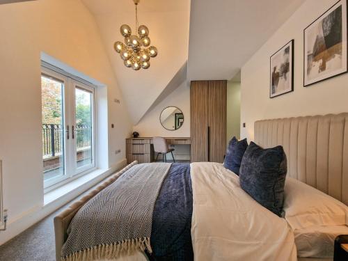 Schlafzimmer mit einem Bett, einem Fenster und einem Kronleuchter in der Unterkunft Luxury 5* Didsbury Family Home in Manchester